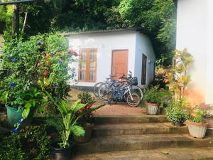 a house with two bikes parked in front of it at Shereen Sigiri Homestay in Dambulla