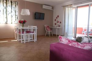 a living room with a purple couch and a table at Apartments Roža in Medulin