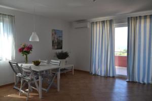 a dining room with a white table and chairs at Apartments Roža in Medulin