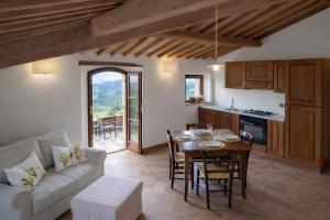 a kitchen and living room with a table and a couch at Podere Montale Il Borgo in Seggiano