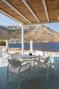 a white table and chairs with a view of the water at Rocks and Waves Sifnos in Kamares