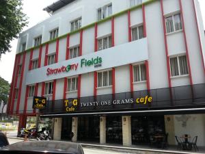 un gran edificio blanco con un cartel. en Hotel Strawberry Fields en Petaling Jaya