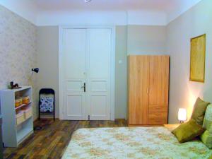 a bedroom with a large bed and a wooden cabinet at Elegant Apartment in Rīga