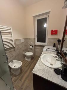 a bathroom with two sinks and a toilet in it at Mary's House in Ciampino