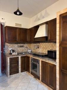 a kitchen with wooden cabinets and a stove top oven at Mary's House in Ciampino