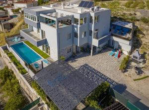 an aerial view of a house with a swimming pool at Apartman Palma and Luxury Penthouse for a family with swiming pool,parking,terrace,panoramic view at the sea,Podstrana in Podstrana