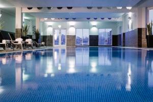 a large swimming pool with blue tiles in a building at The Den - The White House Windermere - Off-Site Health Club & Spa 2 minute walk away in Bowness-on-Windermere