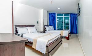 ブカラマンガにあるHotel Isla Mayorのベッド2台と窓が備わるホテルルームです。