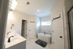 a white bathroom with a sink and a bath tub at Desoto Rental in Olive Branch +16 photos