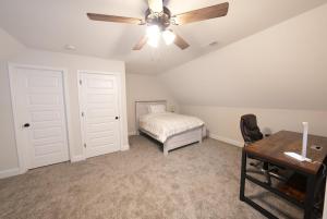 a bedroom with a ceiling fan and a bed and a desk at Desoto Rental in Olive Branch
