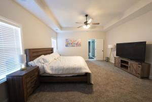 a bedroom with a bed and a flat screen tv at Desoto Rental in Olive Branch
