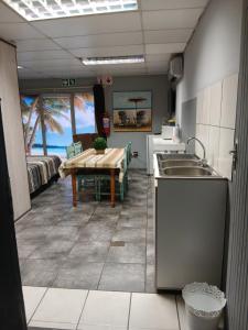 a kitchen with a sink and a table in a room at Platinum Guesthouse in Klerksdorp