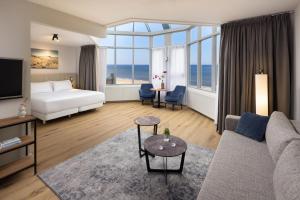 a hotel room with a couch and a bed and a large window at NH Zandvoort Hotel in Zandvoort