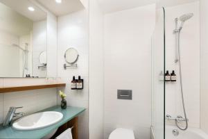 a bathroom with a sink and a shower at NH Zandvoort Hotel in Zandvoort +66 photos