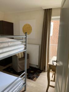 a bedroom with two bunk beds and a desk at Strandhaus Haffkrug in Scharbeutz