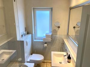 a bathroom with a sink and a toilet and a window at Strandhaus Haffkrug in Scharbeutz +38 photos