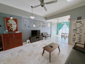 a living room with a tv and a table at Roamia Retreat - Lighthouse in Langkawi Islands