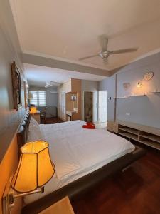 a bedroom with a large white bed with a ceiling at Roamia Retreat - Lighthouse in Langkawi Islands +40 photos