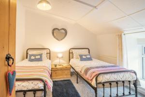 two beds in a room with a heart mirror on the wall at 2 Bed in Trefil oc-n34478 in Nant-y-bwch