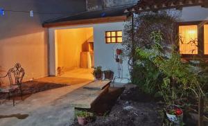 a house with a porch with a bench and plants at Castelli b&b in Mar del Plata +2 photos