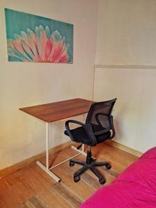 a desk and a chair in a room with a painting at Castelli b&b in Mar del Plata