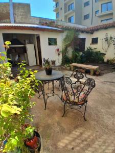a patio with a table and chairs and a building at Castelli b&b in Mar del Plata