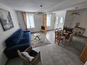 a living room with a blue couch and a table at Gîte de la Tour d'horloge in Carvin