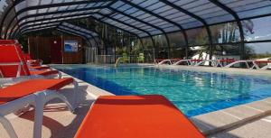 a large swimming pool with red and blue water at Camping La Siesta - Maeva in L'Aiguillon-la-Presqu'île