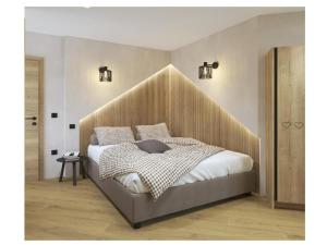 a bedroom with a large bed with a wooden headboard at Golf Apartments in Kranjska Gora