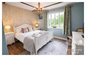 a bedroom with a white bed and a chandelier at Sycamore Lodge in Kilkee