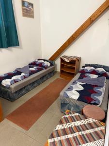 two beds sitting in a room with a staircase at Beach Hostel Balatonboglár in Balatonboglár