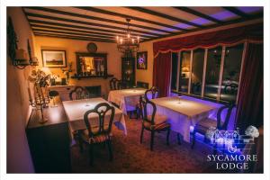 a dining room with two tables with purple lighting at Sycamore Lodge in Kilkee