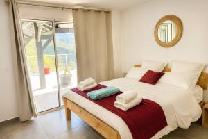 a bedroom with a bed with towels on it at Villa 4 étoiles Le Pic de Malendure in Bouillante +25 photos