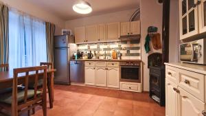 a kitchen with white cabinets and a table and a refrigerator at PORTALA Urban Lodge in Rila