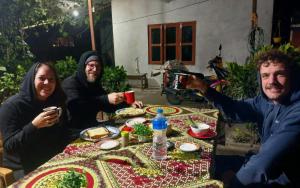 a group of three people sitting around a table at Tiger Corner Inn Homestay in Sauraha