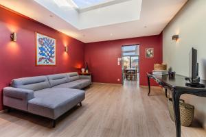a living room with red walls and a couch at Butte du Lion in Genappe