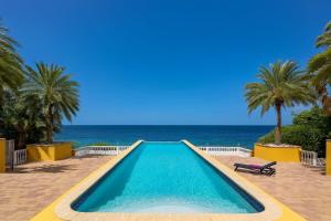 a swimming pool with the ocean in the background at Villa Kas ku Playa 55 - Coral Estate in Willibrordus