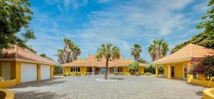 a house with palm trees in the driveway at Villa Kas ku Playa 55 - Coral Estate in Willibrordus