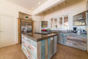 a large kitchen with wooden cabinets and a large island at Villa Kas ku Playa 55 - Coral Estate in Willibrordus