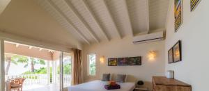 a living room with a bed and a large window at Villa Kas ku Playa 55 - Coral Estate in Willibrordus +18 photos