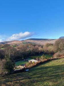 a view of a field with hills in the background at Half Pint Cottage in Draperstown +19 photos