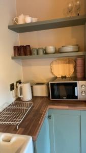 a kitchen with a counter top with a microwave at Half Pint Cottage in Draperstown