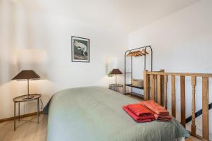 a bedroom with a bed with two lamps and two tables at Butte du Lion in Genappe