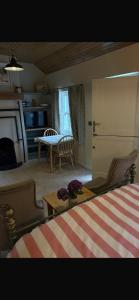 a living room with a bed and a table with flowers at Half Pint Cottage in Draperstown