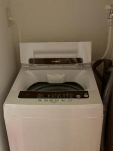 a small white refrigerator with its door open at Runbull House in Tokyo