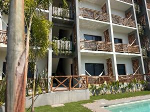 an apartment building with balconies and a swimming pool at Hotel Almendros Bonfil in Acapulco