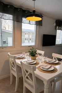 a dining room with a white table and chairs at Frost Longstay City in Kiruna