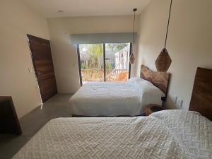 a bedroom with two beds and a window with a view at Hotel Almendros Bonfil in Acapulco
