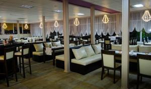 a restaurant with couches and tables in a room at Hotel Tropics & Venera - Ultra All Inclusive in Sveti Vlas