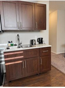 a kitchen with wooden cabinets and a sink at Quiet Comfortable 1-Bedroom in Calgary
